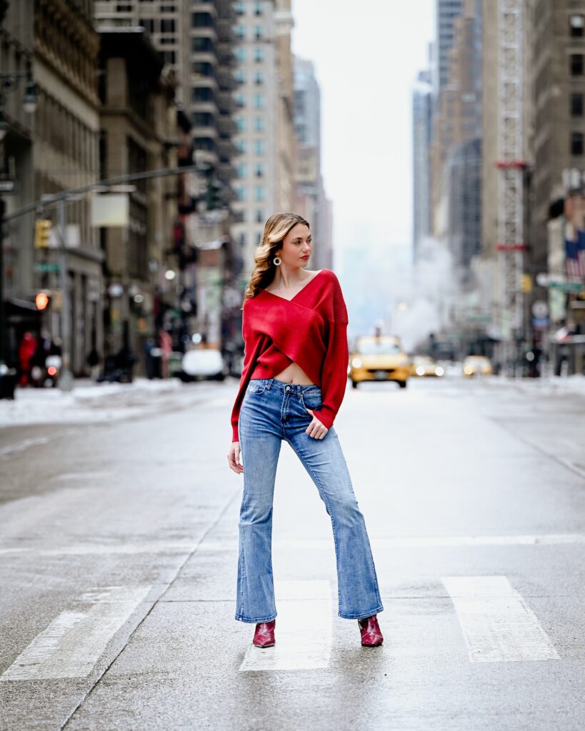 Walking in a city setting in red and denim street-style wardrobe